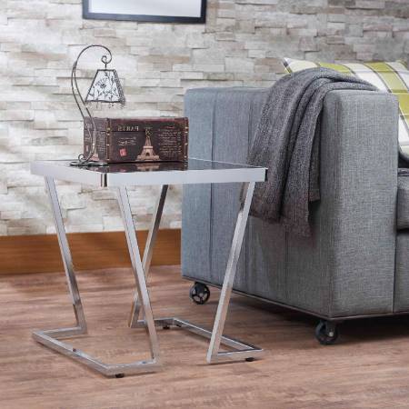 Černě pruhovaná skleněná deska stolu a galvanicky pokovené nohy stolu.