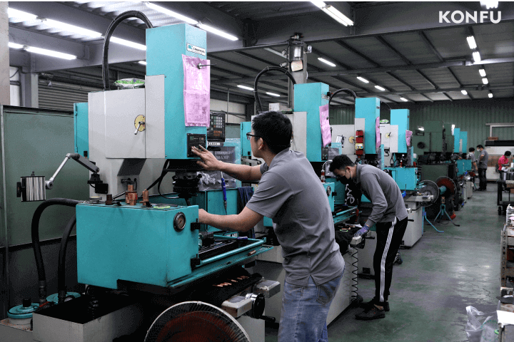 Los técnicos calificados de KONFU operan máquinas avanzadas de conformado en frío para la producción de herramientas de fijación.