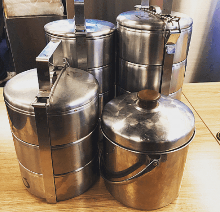 Reusable stainless steel containers used at KONFU to reduce disposable waste