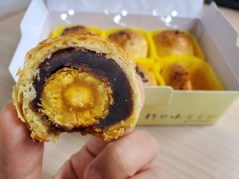 A close-up of a traditional mooncake, a pastry enjoyed during the Moon Festival, showcasing its intricate pattern.