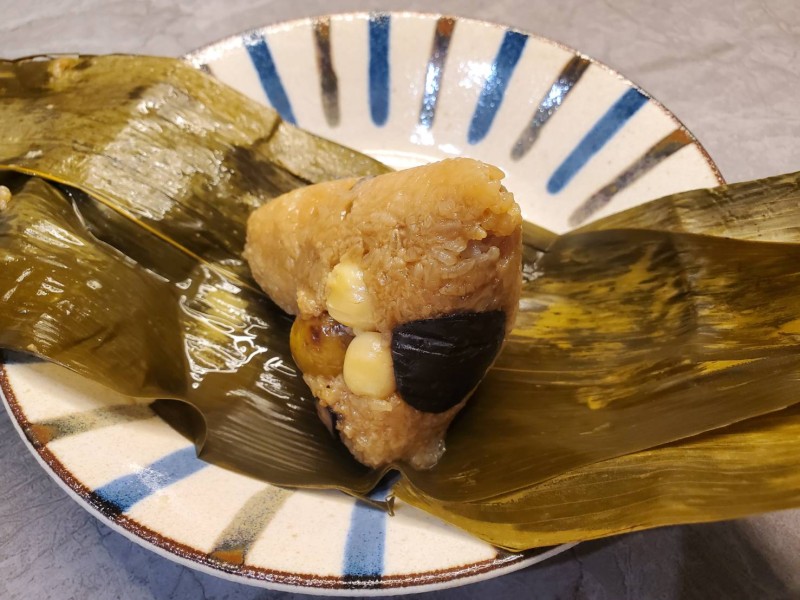 A traditional Taiwanese zongzi, a glutinous rice dumpling, served on a decorative plate during KONFU's Dragon Boat Festival celebration.