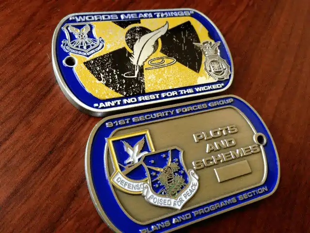 A collection of custom military-style dog tags and challenge coins, representing the evolution from identification to personal accessory.