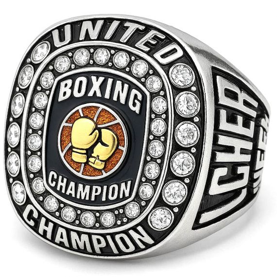 Silver boxing champion ring with gold boxing gloves on an orange textured background, surrounded by sparkling crystals