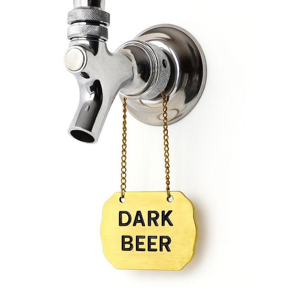 Brass-finished shield-shaped custom metal tap tags for dark beer; elegant gold-tone branding accessories with black recessed text for pubs.