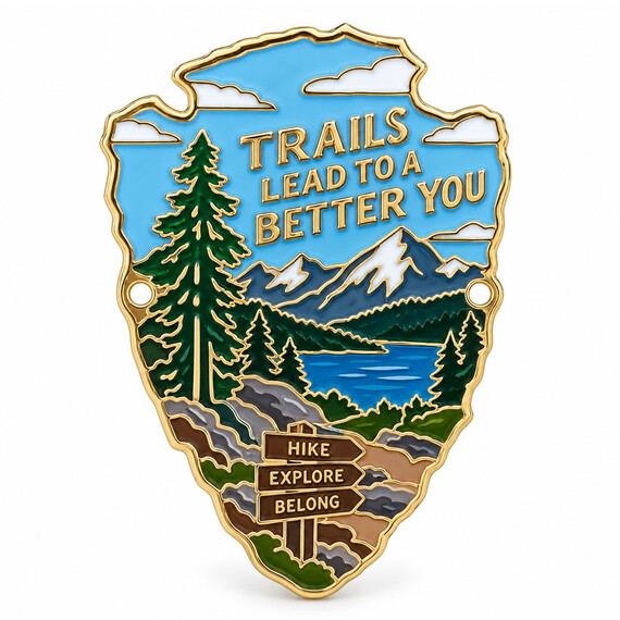 Custom shaped hiking stick medallion with soft enamel mountain, forest and lake design, gold plating and dual mounting holes.