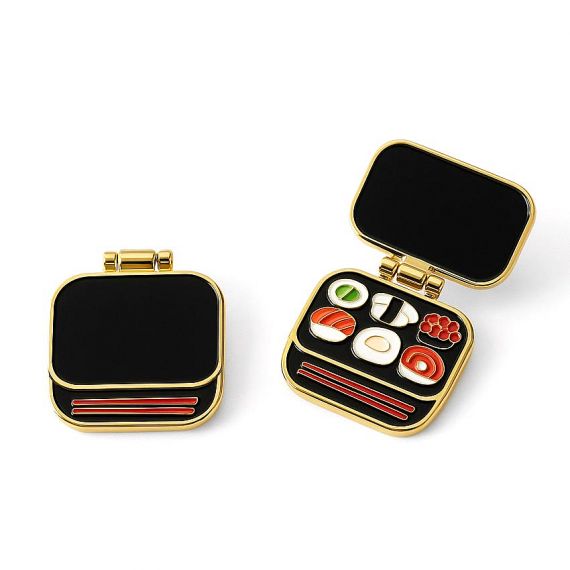 Bento box style hinged pin that opens to showcase a colorful sushi set. Sushi souvenir lapel pin.