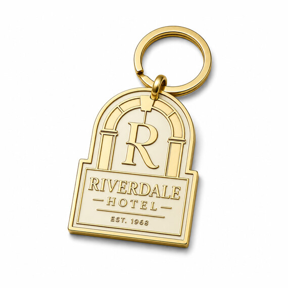 Custom gold hotel logo keychain shaped around an arched entrance with raised monogram and lettering