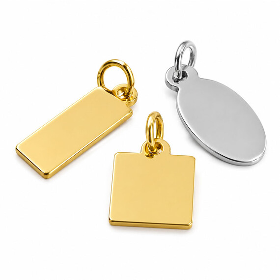Blank stock jewelry tags in rectangular, square, and oval shapes with polished gold and silver finishes, ready for custom logo engraving or printing.