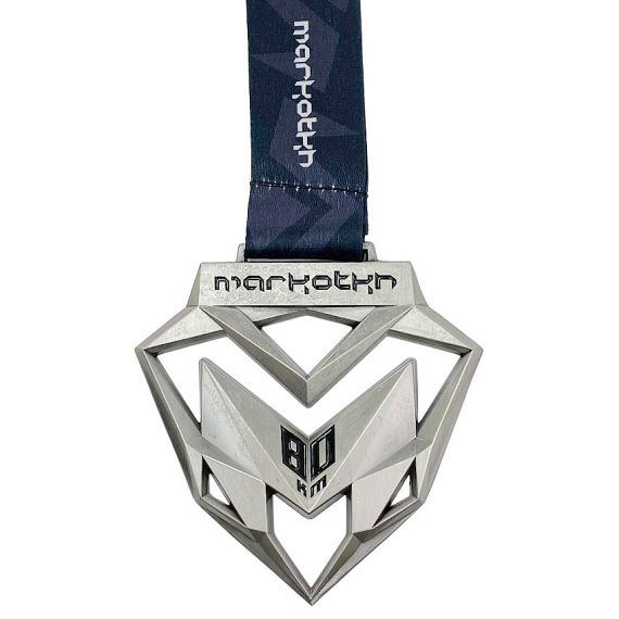 Geometric silver running race medal with cutout design and navy ribbo