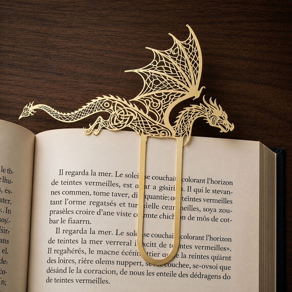 Custom metal bookmark with a polished gold finish, featuring intricate filigree cutout patterns, resting within the pages of an open book.