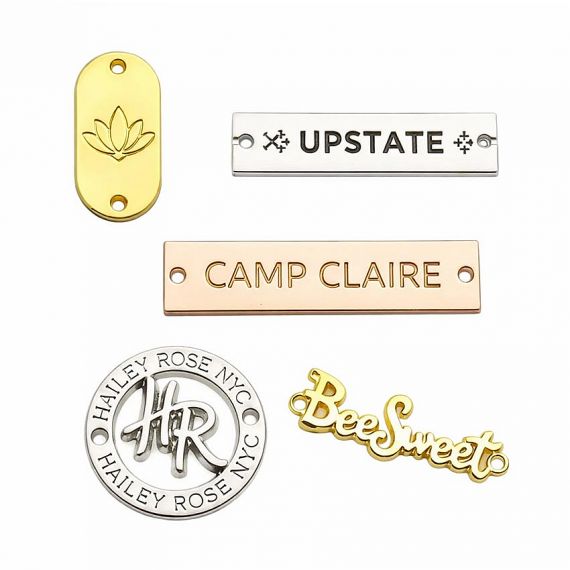 Custom Metal Label Tags - Custom metal logo plates in polished gold, silver, and rose gold finishes; high-quality embossed branding labels for luxury handbags and accessories.