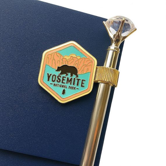 Custom Yosemite National Park hexagon enamel pen holder clip, luxury gold-plated notebook accessory with secure spring loop.