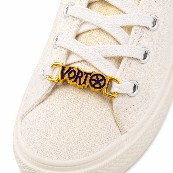 Etiqueta de cordón personalizada con logotipo en oro con letras de esmalte púrpura instaladas en cordones de zapatillas blancas