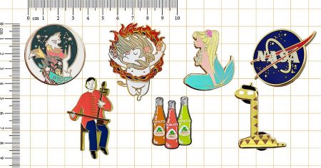 6 Key Design Rules for Custom Lapel Pins | Perfect for Beginners - A collection of custom enamel pins with diverse designs, including characters and logos, displayed on a grid with a ruler for size reference.