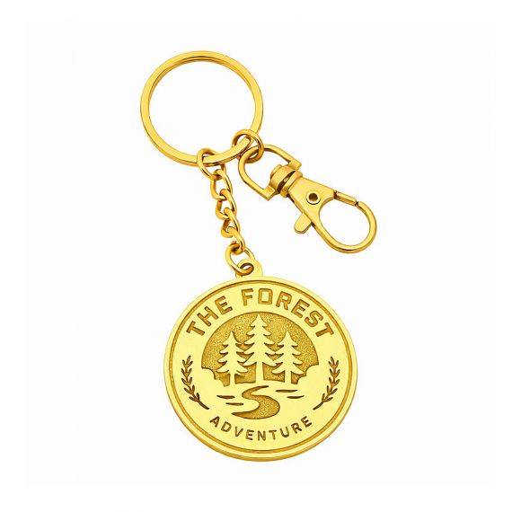 Stamped brass polished shiny gold finish keychain featuring a circular forest landscape
