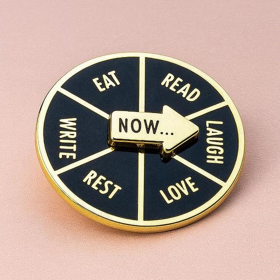 Interactive spinning lapel pin featuring a movable decision wheel.
