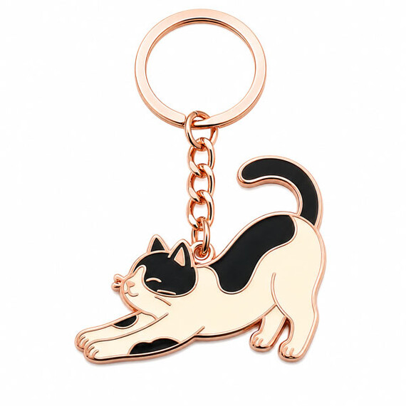 Rose gold cat-shaped enamel keychain with black and cream details.