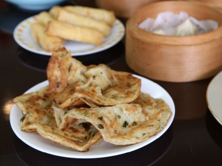 Chopped Scallions are evenly distributed on the Pancake
