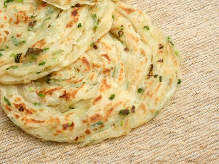 Chopped scallions are automatically and evenly sprinkled onto the Pancakes