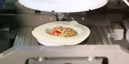 Empanada wrapper and filling is placed in the Clamping Mold Device