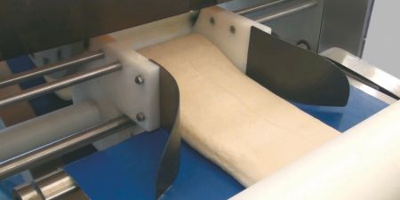 Formowanie i dociskanie ciasta do nadziewanego arkusza ciasta.