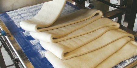 Układanie i składanie nadziewanego arkusza ciasta do dalszego dociskania.