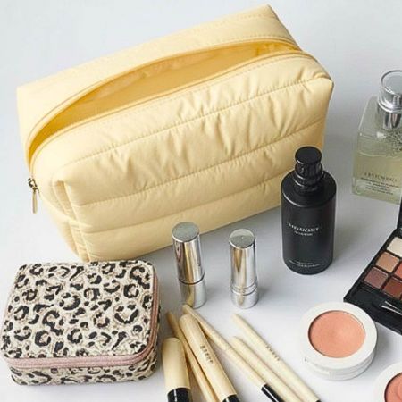 Pastelgul quilted puffer taske åbnet med kosmetik