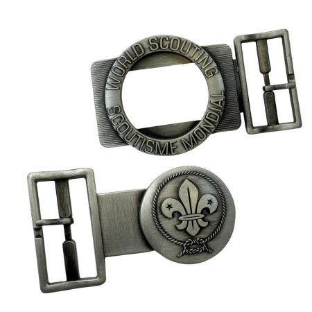 ส่วนประกอบหัวเข็มขัดเข็มขัดลูกเสือ 2 ชิ้นในโลหะเงินขัดเงา แสดงกรอบวงกลมพร้อมข้อความลูกเสือโลกและสัญลักษณ์ฟลูร์-เดอ-ลิส