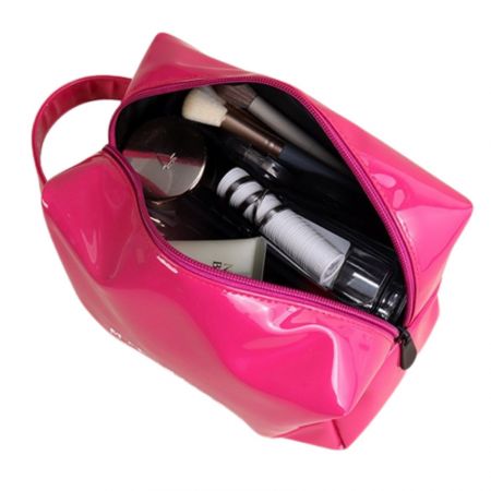 Trousse de maquillage de voyage montrée ouverte, révélant des cosmétiques à l'intérieur