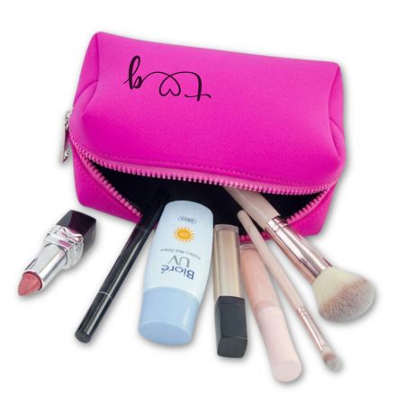 Pink neoprene daily makeup organizer with zipper opening filled with cosmetics including brushes, lipstick, and skincare bottle