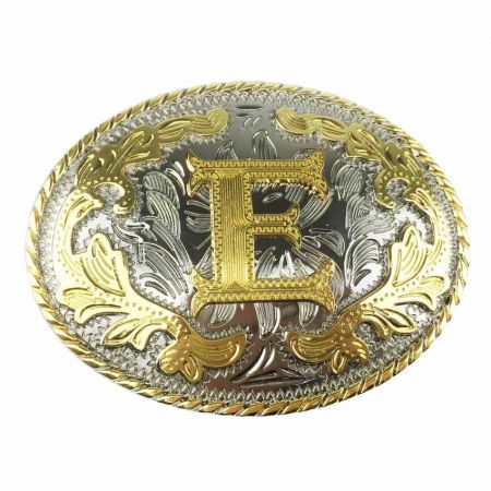 Soikea vyönsolki, jossa kultainen E hopeataustalla