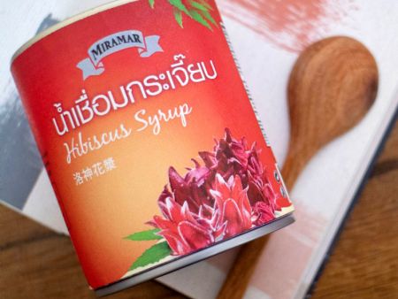 Hibiscus blossoms in syrup serving in tin can.