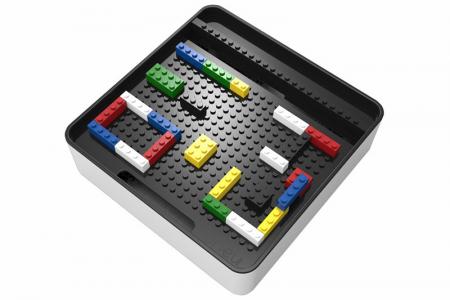 Caja de ladrillos divertida ONEU organizador de móviles y accesorios en uso.