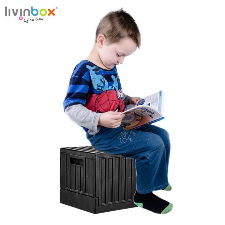 A boy sits on the small plastic storage bin