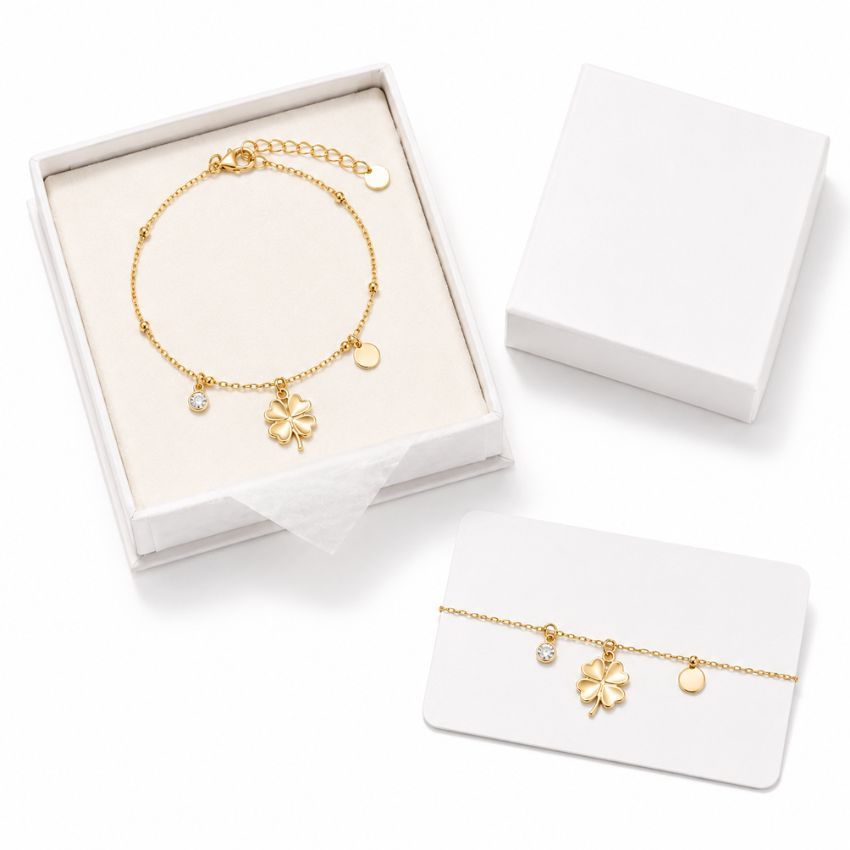 Gold clover charm bracelet in a white gift box with display card, perfect for wholesale fashion jewelry suppliers.