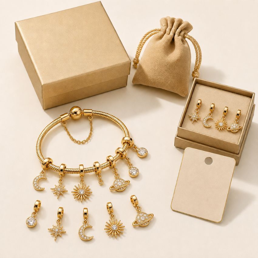 Gold celestial charm bracelet with star and moon pendants, displayed with custom jewelry gift box for wholesale supply.