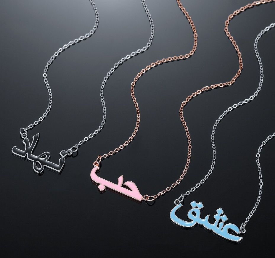 Eine Kollektion von drei benutzerdefinierten arabischen Wörtern Emaille-Anhänger-Halsketten in verschiedenen Farben, die das 'Liebe'-Anhänger-Design von JR Fashion Accessories präsentieren.