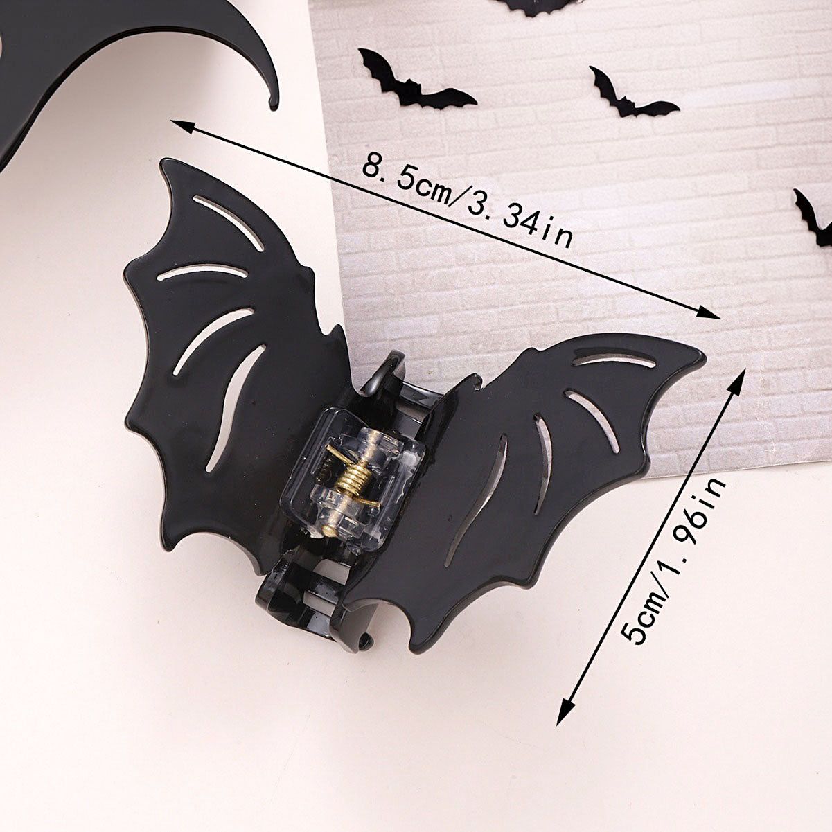 Une pince à cheveux en forme de chauve-souris noire avec un design détaillé en creux, idéale comme accessoire d'horreur antidérapant pour Halloween.