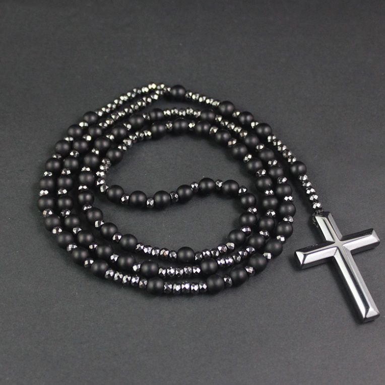 Vista dettagliata di una collana rosario personalizzata con perle nere e un pendente a croce in argento sterling lucido, prodotta da JR Fashion Accessories.