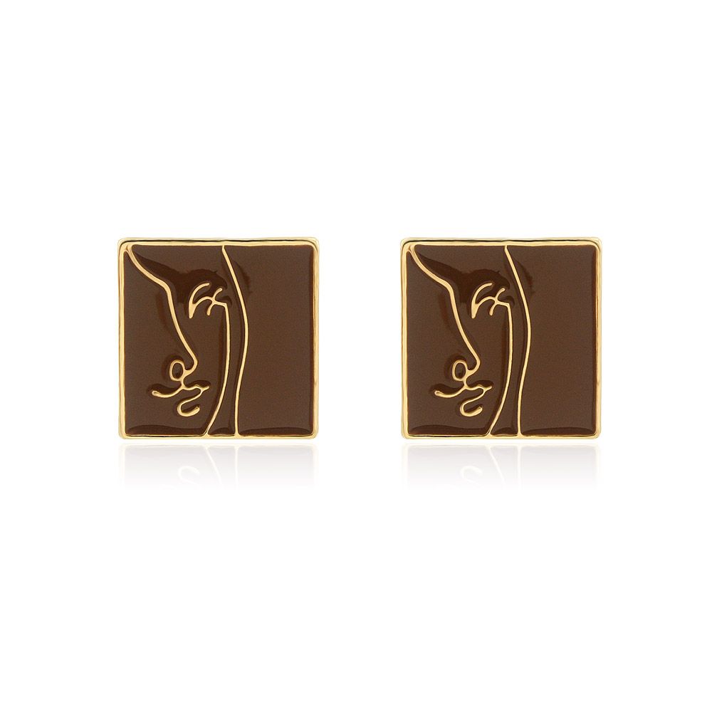 Un par de Pendientes de Botón con Cara de Esmalte Marrón con un diseño de perfil chapado en oro único sobre un fondo blanco.