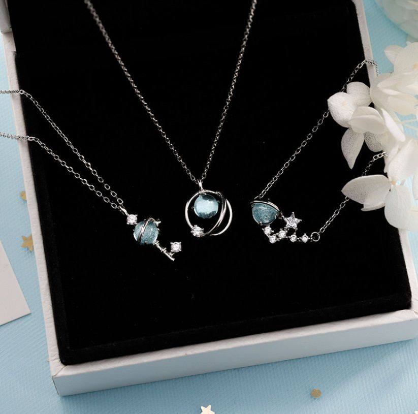 A collection of three 925 sterling silver blue opal necklaces with celestial-themed pendants, including planets and stars, offered by JR Fashion Accessories.