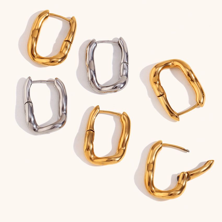 A collection of women's stainless steel rectangular huggie hoop earrings, displayed in both gold and silver finishes, highlighting their chunky and modern design.