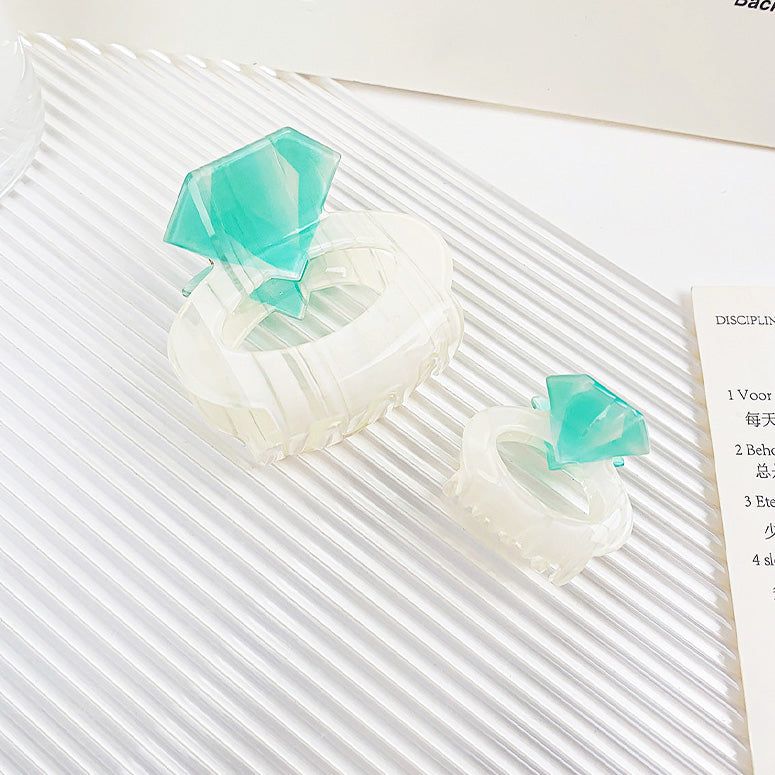中央にターコイズの宝石を持つ、1つは大きい（5.5cm）、もう1つは小さい（3.5cm）のアクリルダイヤモンドリング型ヘアクリップのクローズアップ。