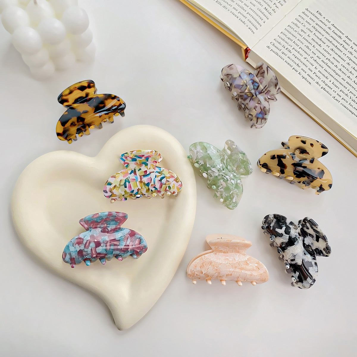 A vibrant arrangement of colorful tortoise shell acetate hair claw clips, showcasing various patterns and a strong hold design.