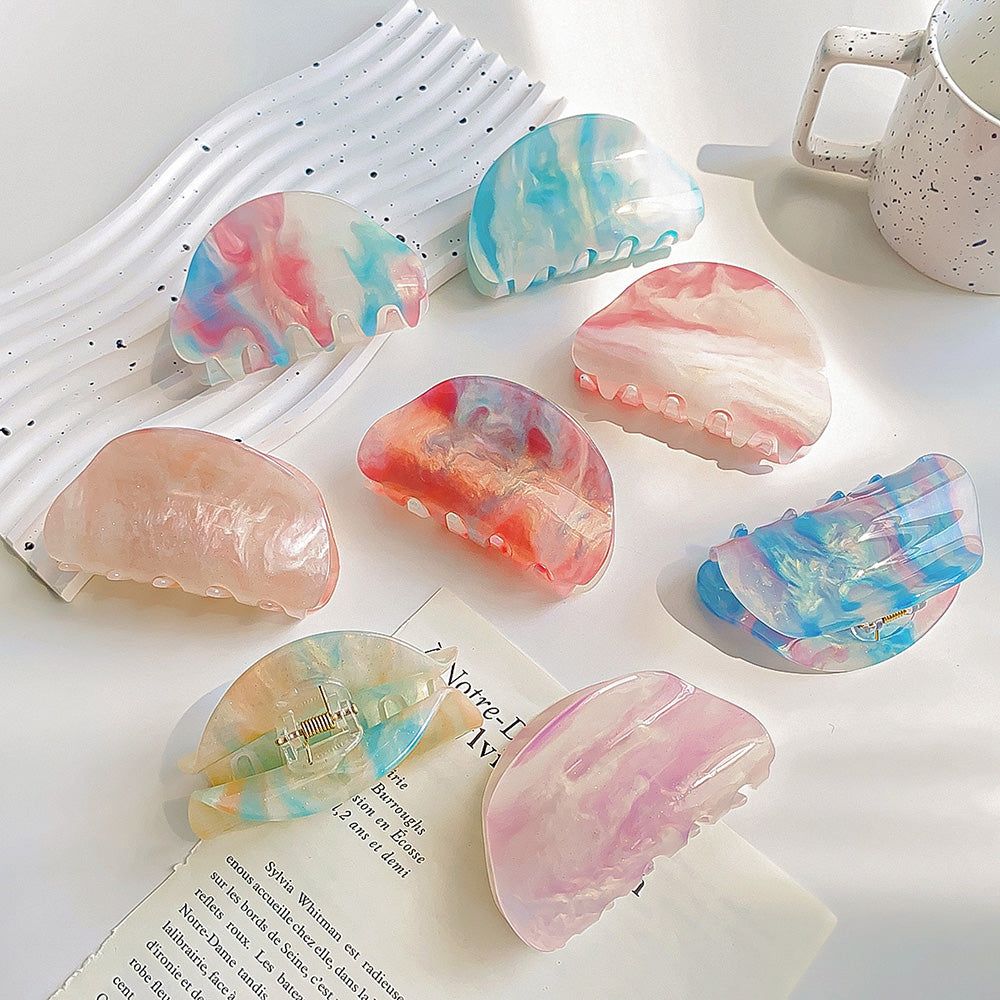 Un vibrante conjunto de pinzas de pelo acrílicas semicirculares de acetato de cambio de color especial con un hermoso efecto veteado.