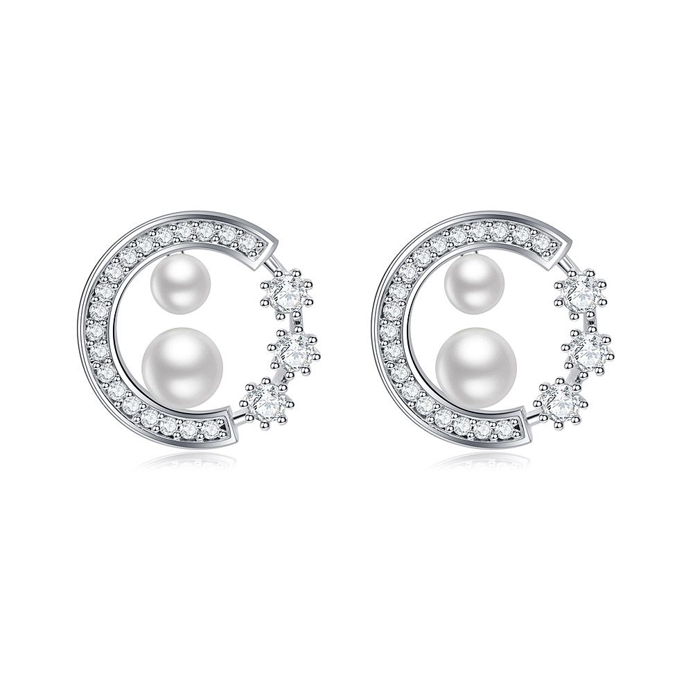 Un par de pendientes de perla atractivos en diseño de luna creciente, con zirconia cúbica blanca y perlas, exhibidos sobre un fondo blanco limpio.