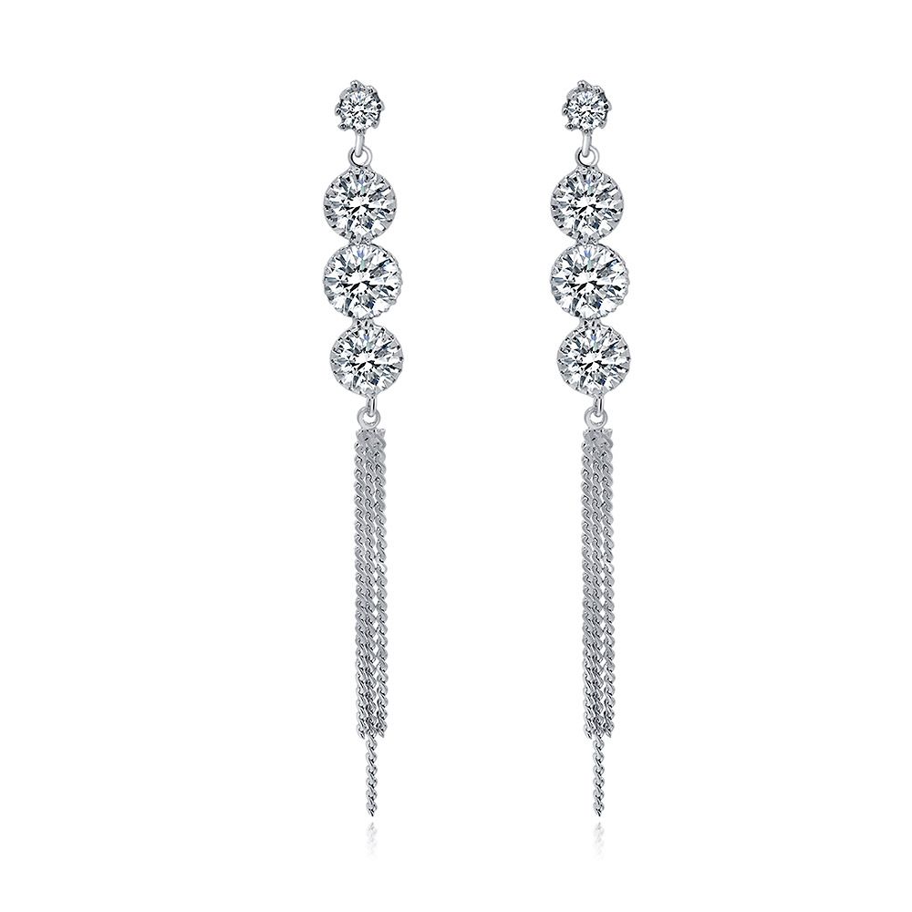 Un par de pendientes de cadena larga con cuatro piedras, con cristales de circonio cúbico apilados y elegantes detalles de borlas de plata, contra un fondo blanco.