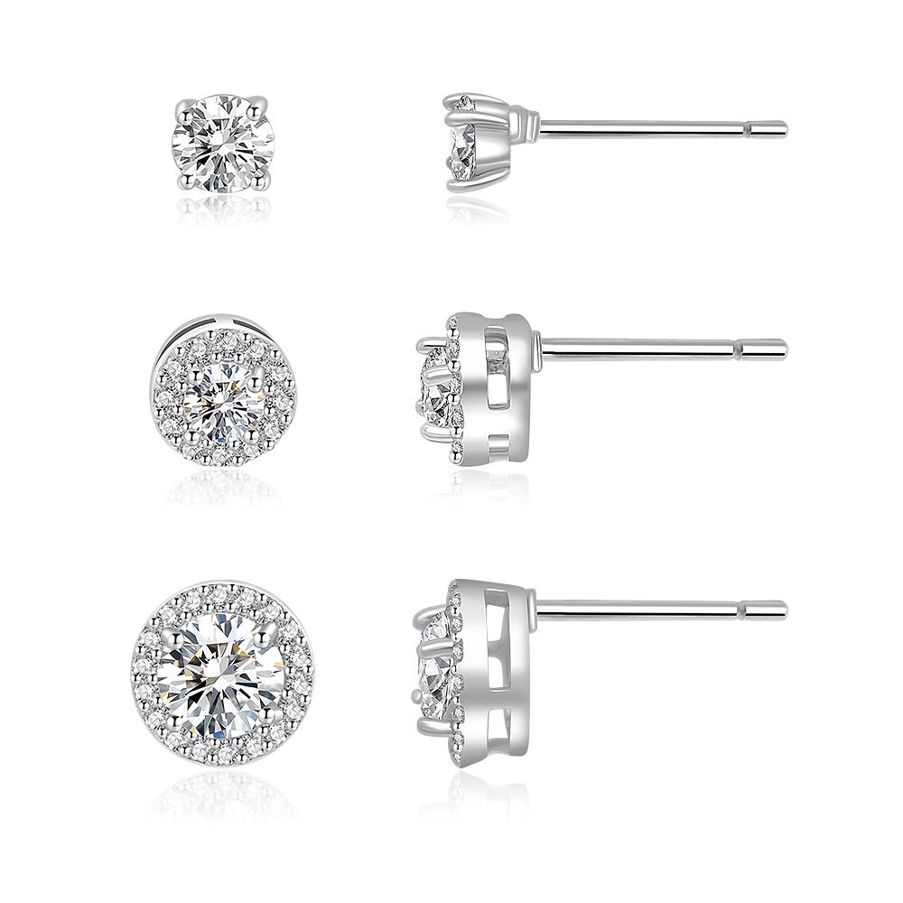 Un conjunto de tres pares de aretes de studs de rodio con circonitas cúbicas, mostrados en tres tamaños y configuraciones diferentes.