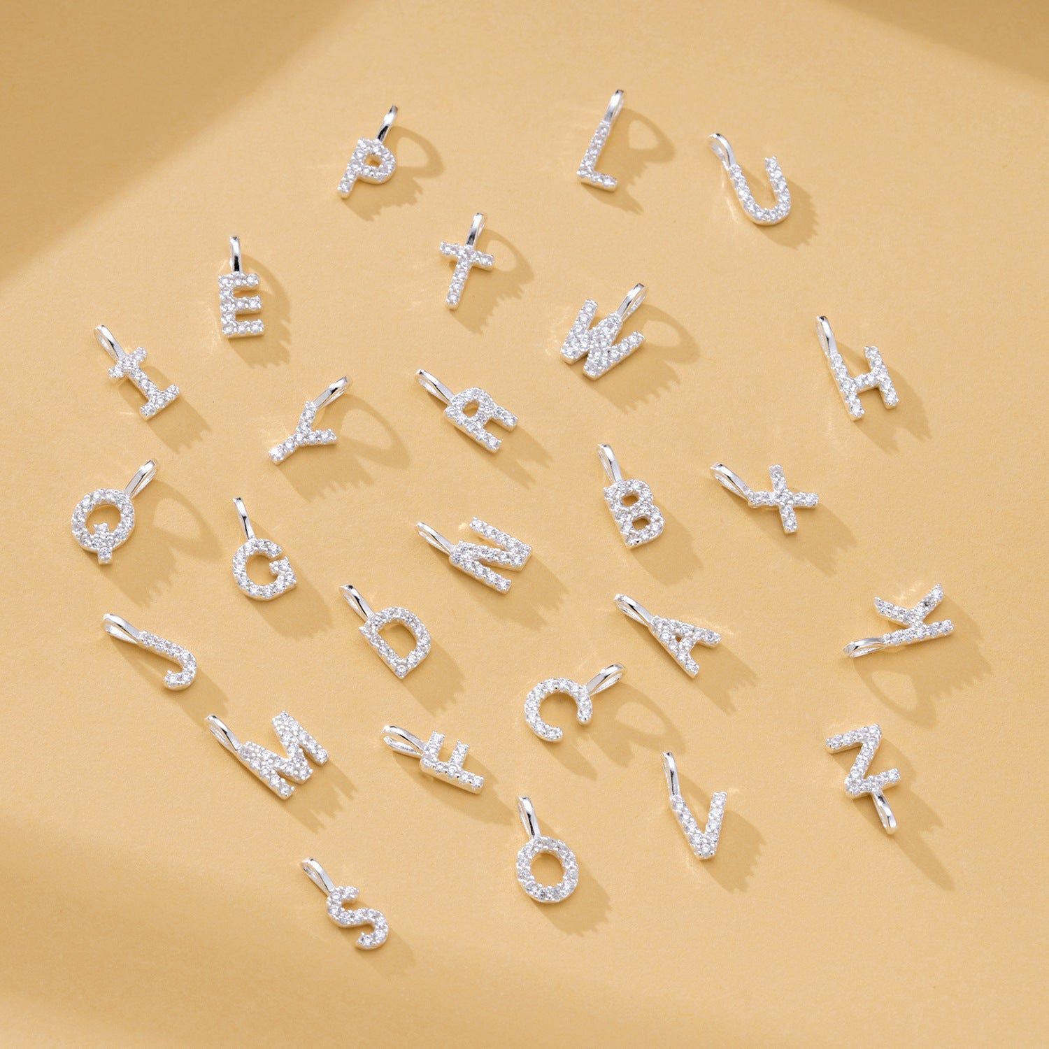 A collection of 925 sterling silver alphabet letter pendants, each fully encrusted with sparkling zircon stones, displayed on a clean white background.