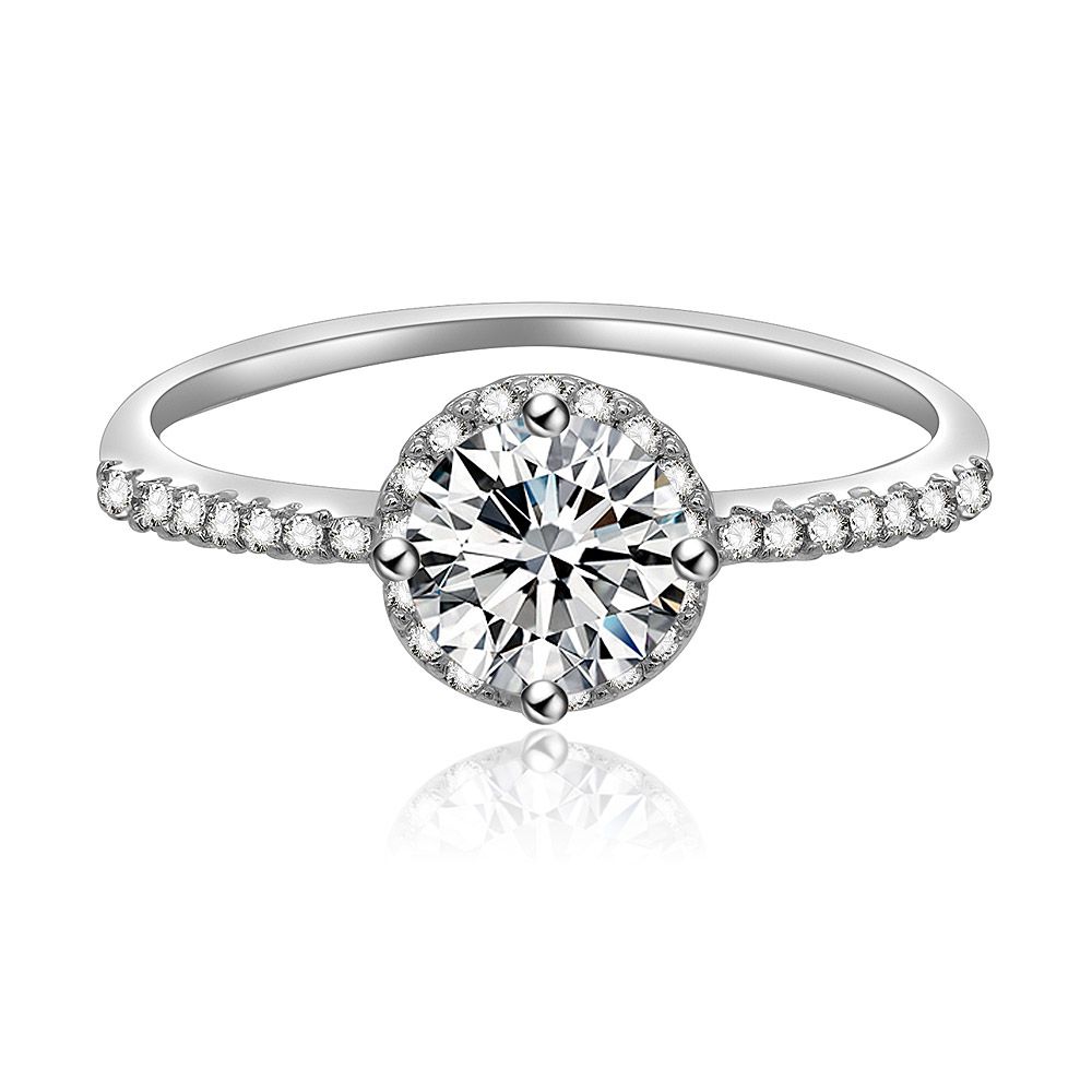 Un primo piano dell'anello di fidanzamento a halo brillante rotondo, che mostra la pietra centrale in zirconia cubica da 5 mm circondata da un halo di pietre più piccole su una fascia placcata in rodio.